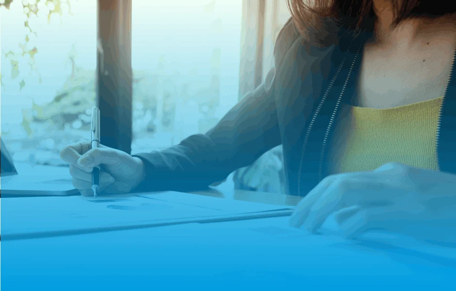 A woman working through documents on her desk.