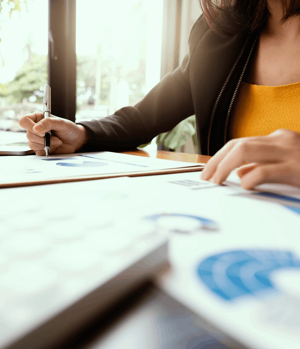 Woman working at a desk sorting through job applications.